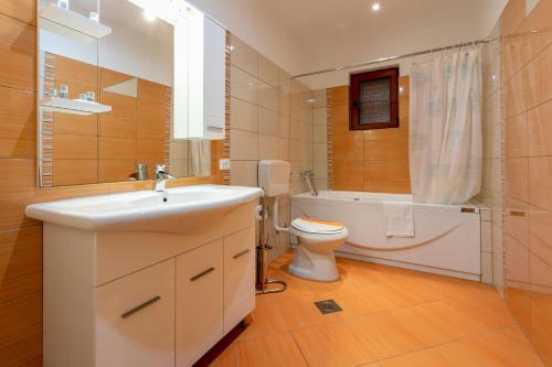 a bathroom with a sink and a toilet and a tub at House Marija in Lopar
