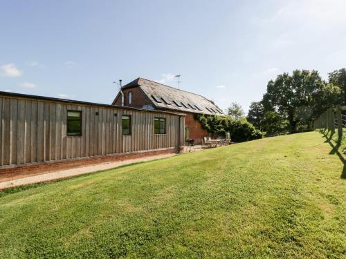 a barn with a grassy yard next to a building at Breaches Barn in Rockbourne