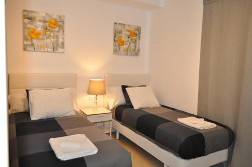 - 2 lits dans une petite chambre avec fenêtre dans l'établissement Villa Cástor, à Playa Blanca
