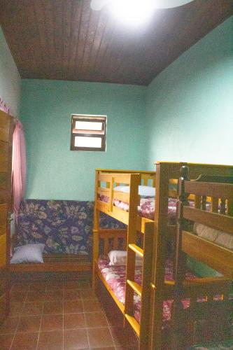 a room with two bunk beds and a window at Casa do Carlos, praia da Enseada Ubatuba-SP in Ubatuba