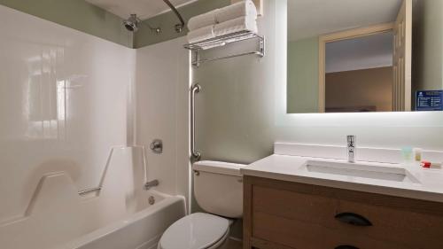Best Western Inn & Suites Rutland-Killington في روتلاند: حمام مع حوض ومرحاض ومرآة