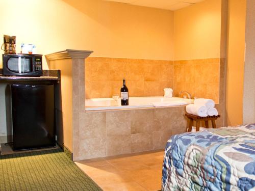 bagno con vasca, letto e forno a microonde di Quality Inn East Stroudsburg - Poconos a East Stroudsburg