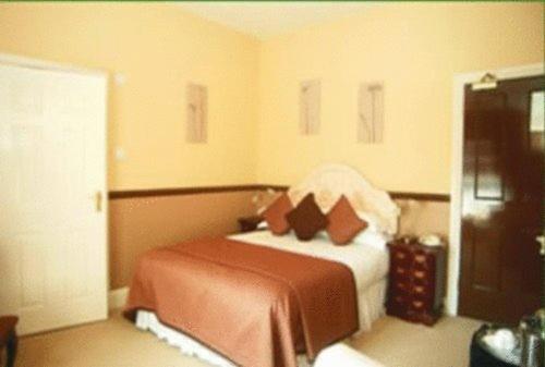 a bedroom with a bed with brown and white at La Fleur De Lys in Shaftesbury