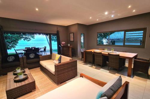 a living room with a table and a dining room at Villa Meheana in Moorea