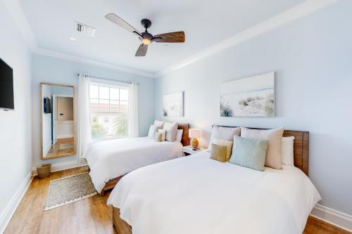 two beds in a room with a ceiling fan at BrightWater Blue 158-2 in Clearwater Beach