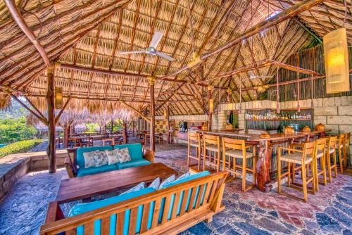 a resort with a bar and tables and chairs at Morgan's Rock in San Juan del Sur
