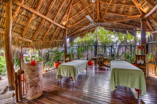ein Zimmer mit zwei Tischen in einem Bambusgebäude in der Unterkunft Morgan's Rock in San Juan del Sur