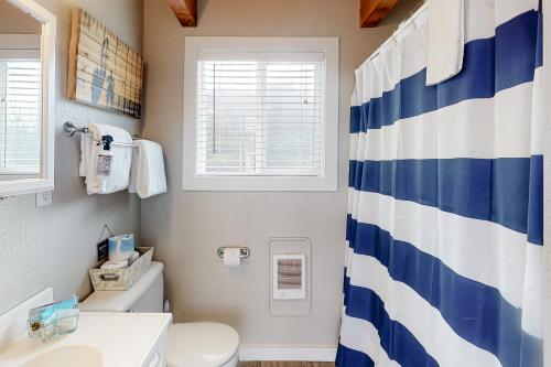 a bathroom with a blue and white shower curtain at Lofty Pelican in Florence