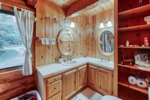 a bathroom with two sinks and two mirrors at Log Cabin with a View in Andover