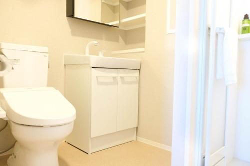 bagno con servizi igienici bianchi e specchio di The Light Inn - Vacation STAY 94696 a Tokyo