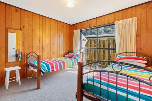 two bunk beds in a room with a window at Downtown Mountview - Mt Maunganui Holiday Home in Mount Maunganui