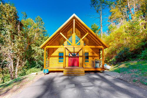 a wooden cabin in the middle of a forest at Knotty Escape in Gatlinburg