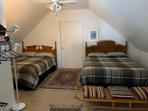 1 dormitorio en el ático con 2 camas y ventilador de techo en Va Beach Zen tree house style studio F en Virginia Beach