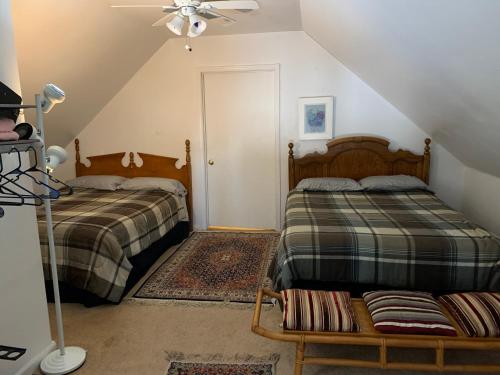 a attic bedroom with two beds and a ceiling fan at Va Beach Zen tree house style studio F in Virginia Beach