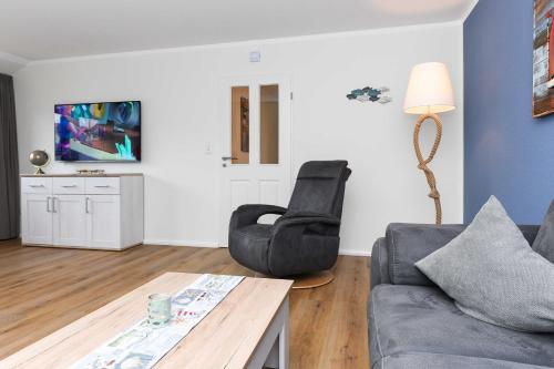a living room with a couch and a chair at Ferienwohnungen Min Huus in Neuharlingersiel