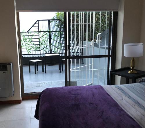 a bedroom with a bed and a view of a balcony at Departamento Céntrico Bariloche con patio in San Carlos de Bariloche
