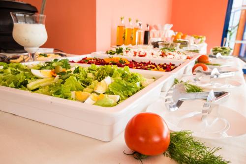 阳光海滩Hotel Bohemi的桌子上摆着自助餐台，上面放着沙拉和西红柿。