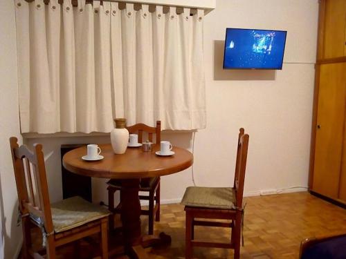 mesa de comedor con 2 sillas y TV en Cortina en Buenos Aires