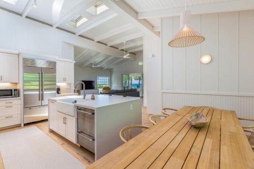 a kitchen with a wooden table and a dining room at Camp Alealea 2 home in Hanalei