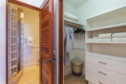 a walk in closet with a wooden door at Camp Alealea 2 home in Hanalei