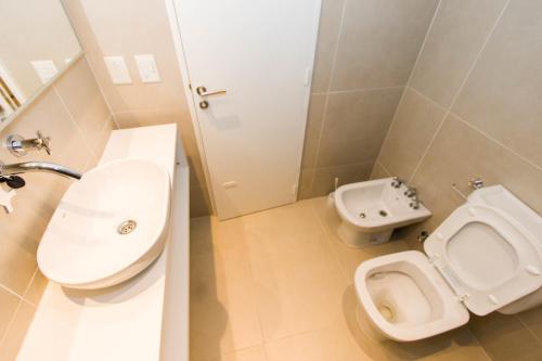a bathroom with a toilet and a sink at Austral Departamentos in Ushuaia