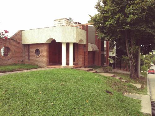 a brick building with a lawn in front of it at Hostería Familiar El Ceibo in San Salvador de Jujuy