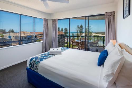 a bedroom with a large bed and a large window at Belaire Place in Caloundra