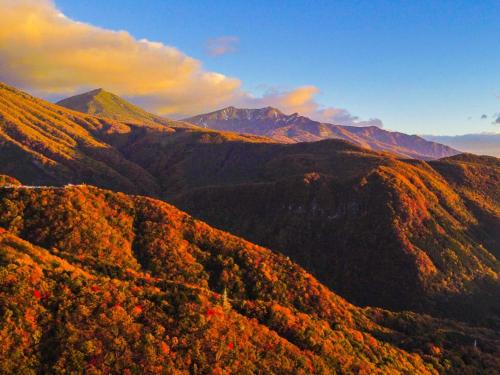 an autumn view of a mountain range with trees at Lake Side Nikko Hotel in Nikko