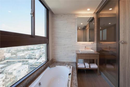 bagno con vasca e ampia finestra di Grand Bay Resort Hotel a Città Vecchia di Hengchun