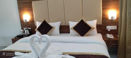 two swans towels on a bed in a hotel room at Seven Corbett in Rāmnagar