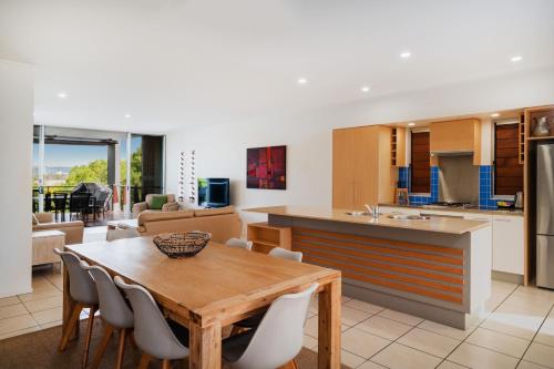 a kitchen and dining room with a table and chairs at The Sebel Twin Waters in Twin Waters