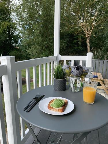 a table with a piece of bread and a plate of food at Percy Wood Lodges with Hot Tubs in Swarland