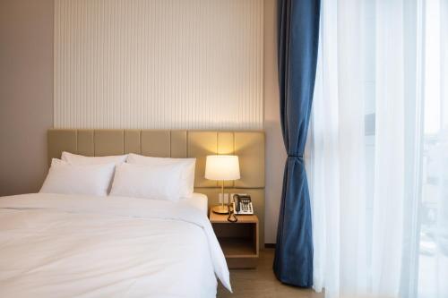 a bedroom with a bed and a blue curtain at Jeonju Tourist Hotel kkotsim in Jeonju