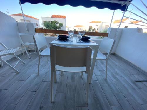 a table and chairs on a balcony with a table and wine glasses at Los Cristianos port royal in Los Cristianos