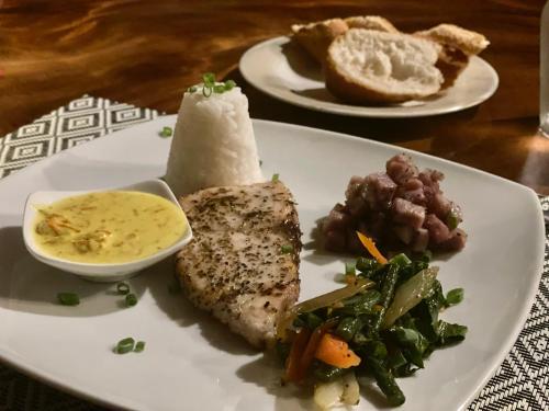 a plate of food with meat and vegetables on a table at Pension TUPUNA in Haapu