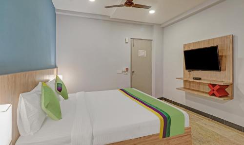 a bedroom with a bed and a flat screen tv at Itsy Hotels Classio Richmond in Bengaluru
