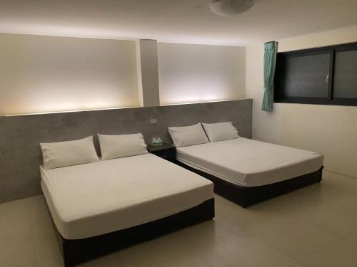 two beds sitting in a room withermottermottermott at Home Rest B&B in Lijia