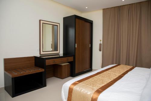 a bedroom with a bed and a dresser and a mirror at فندق لامير إن Lamer in Hotel in Sharurah