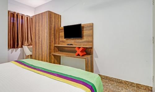 a bedroom with a bed and a tv on a desk at Itsy Hotels Classio Richmond in Bengaluru