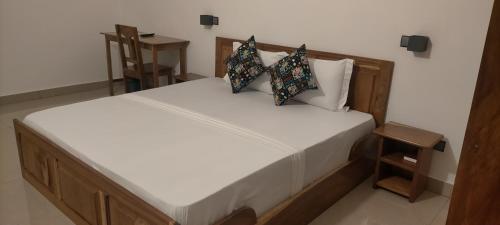 a bedroom with a bed with white sheets and pillows at AZURIA HOTEL in Lomé