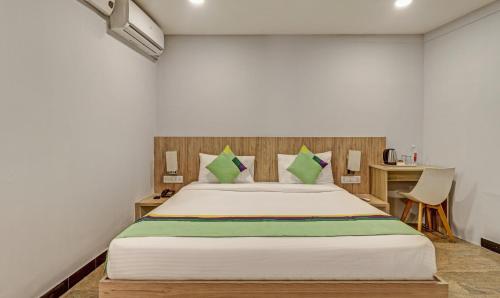 a bedroom with a large bed and a desk at Itsy Hotels Classio Richmond in Bengaluru