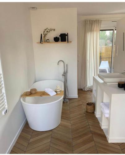 une salle de bain blanche avec une baignoire et un lavabo dans l'établissement Casa louisa chambre sauna et bain nordique, à Wailly-Beaucamp