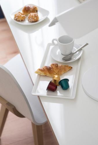 a table with a plate of pastries and a cup of coffee at Hotel Max in Paris
