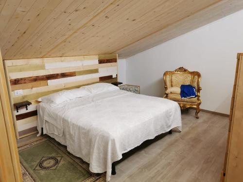 a bedroom with a large bed and a chair at VILLA FELICIA in Torino di Sangro