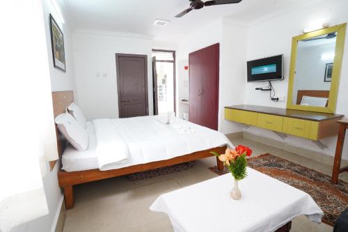 a bedroom with a bed and a mirror and two tables at Hotel TamilNadu - Yercaud in Yercaud