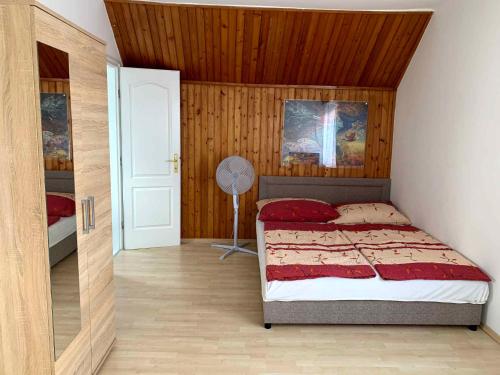 een slaapkamer met een bed en een ventilator. bij Apartment in Balatonlelle 19129 in Balatonlelle