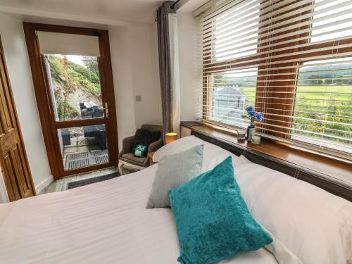 a bedroom with a white bed and a window at The Lodge in Ulverston