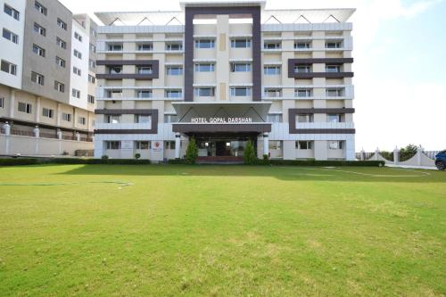ein großes Gebäude mit großem Rasen davor in der Unterkunft The Sky Imperial- Hotel Gopal Darshan in Nāthdwāra