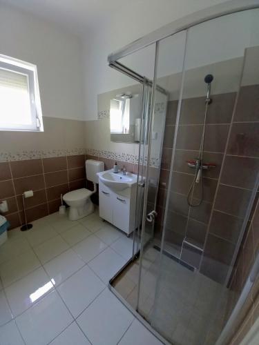 a bathroom with a shower and a toilet and a sink at Zámor Nyaraló in Keszthely