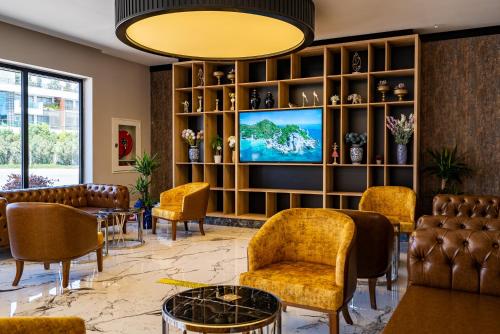 a lobby with chairs and a tv on a wall at Side Amour Hotel in Side